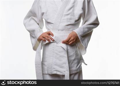Stages of correct tying of the belt by a teenager on a sports kimono, step five