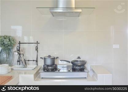 stainless pan on gas stove with utensil in modern kitchen