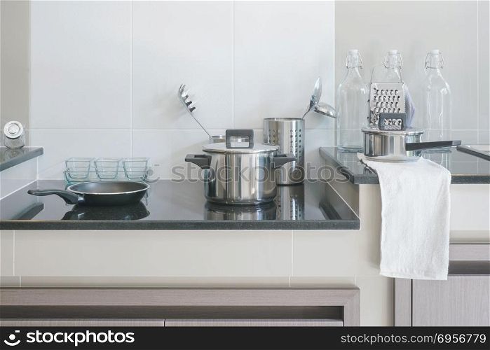 Stainless steel kitchenware on black top counter