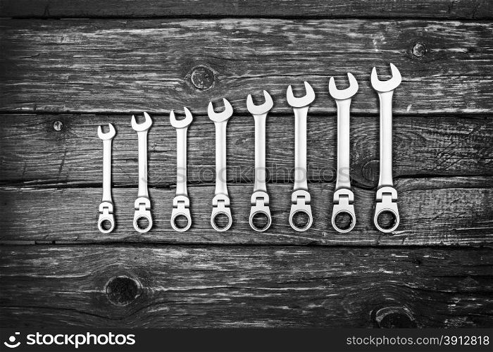 Stainless steel wrench set on wood background, black and white photo