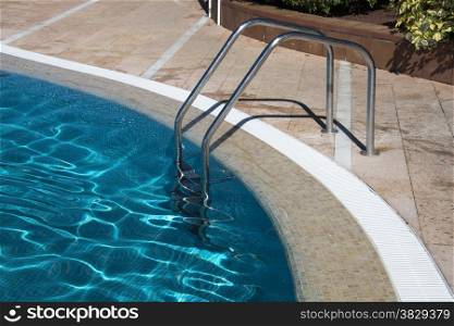 staircase in blue water swiming pool