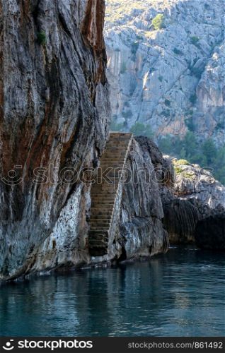Stairs carved in stone lead from rock face into the sea