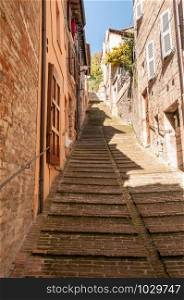 Stairs in a rising street in Urbino , a renaissance city in Marche, Italy