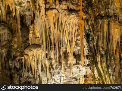 Stalactites and stalagmites underground in cave system in Postojna. Strange rock formations underground in cave system