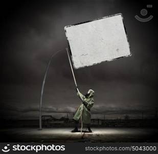 Stalker in gas mask. Man in gas mask and camouflage pulling blank banner. Place for text