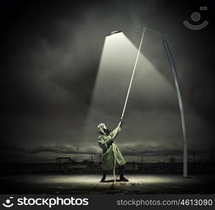 Stalker in gas mask. Man in gas mask and camouflage standing under street light