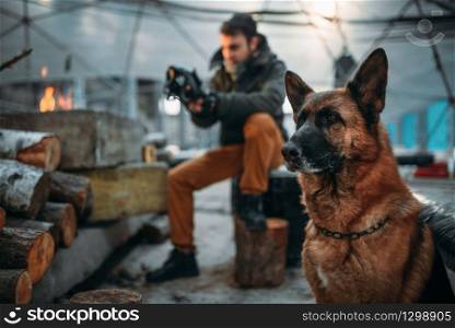 Stalker measures the radiation level in nuclear explosion zone against his dog. Post apocalyptic lifestyle on ruins, doomsday, judgment day