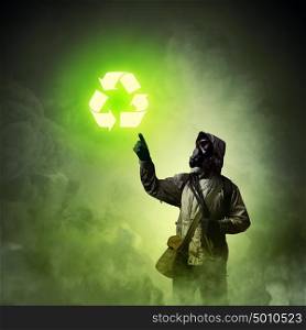 Stalker touching sign. Image of man in gas mask and protective uniform touching recycle sign