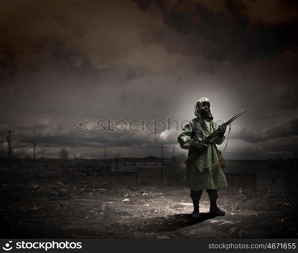 Stalker with gun. Man in gas mask and camouflage holding gun. Disaster concept