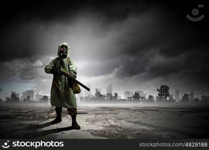 Stalker with gun. Man in gas mask and camouflage holding gun. Disaster concept