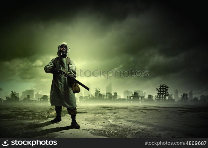 Stalker with gun. Man in gas mask and camouflage holding gun. Disaster concept