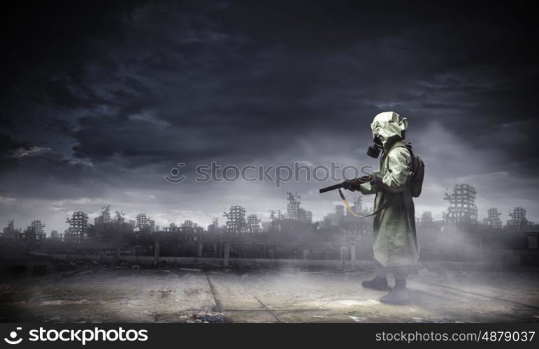 Stalker with gun. Man in gas mask and camouflage holding gun. Disaster concept