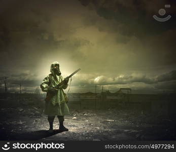 Stalker with gun. Man in gas mask and camouflage holding gun. Disaster concept