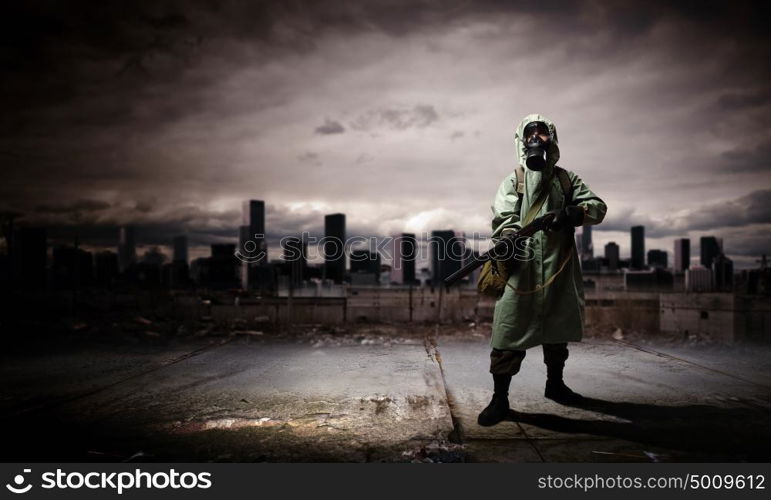 Stalker with gun. Man in gas mask and camouflage holding gun. Disaster concept