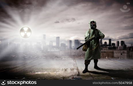 Stalker with gun. Man in gas mask and camouflage holding gun. Disaster concept