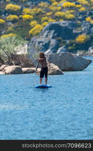 Stand up paddleboarding on lake. Watersport on lake. Tourist outdoor activity at Lagoa Comprida, Serra da Estrela National Park in Portugal.