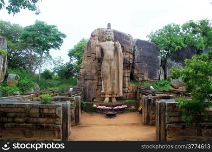 Standing Aukana Buddha an d ruins of temple in Sri Lanka