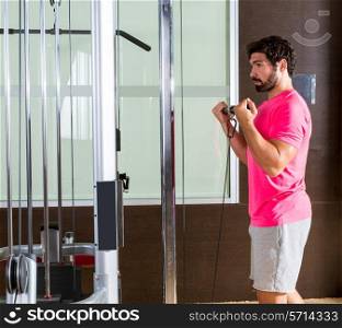 Standing biceps cable curl man in pulley machine workout at gym