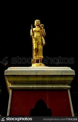 Standing Buddha Statue with long handled umbrella and walking stick in Wat Phra That Doi Phra Chan in Mae Tha District Lampang Thailand