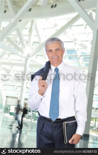 Standing Businessman with Jacket over his Shoulder in Building Lobby