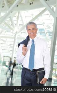 Standing Businessman with Jacket over his Shoulder in Building Lobby