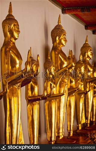 Standing golden Buddha statues close up. Wat Pho temple, Bangkok, Thailand