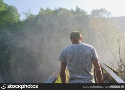 standing man with wide opened arms with waterfalls in background and representing freshness healthy lifestyle and success concept