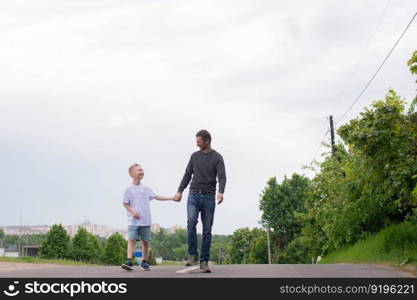 standing next to the child, teaching the son, showing the direction, entertaining the child, studying, dad, son, child, father, upbringing, development, interest, watching, playing, family vacation, nature walk, spring, reaching for flowers, blooming tree. A father walks with his son on the road. The child is indulging