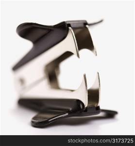 Staple remover on white background with selective focus.
