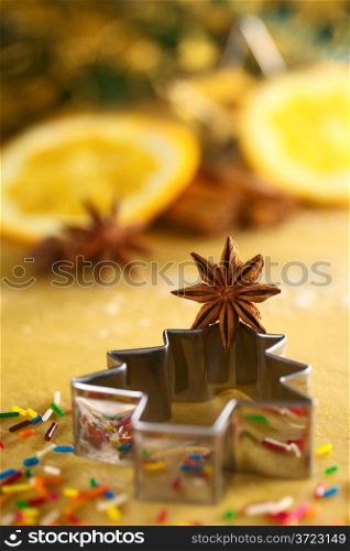 Star anise on Christmas tree shaped cookie cutter lying on dough (Selective Focus, Focus on the middle of the anise). Star Anise on Christmas Tree Cookie Cutter