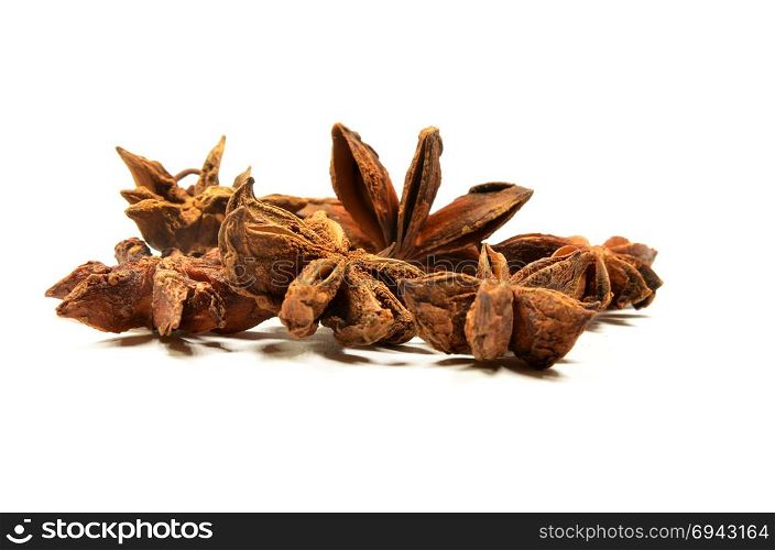 Star anise spice fruit and seeds on a white surface