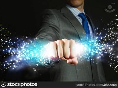Star dust. Close up of businessman hand holding light ray in fist
