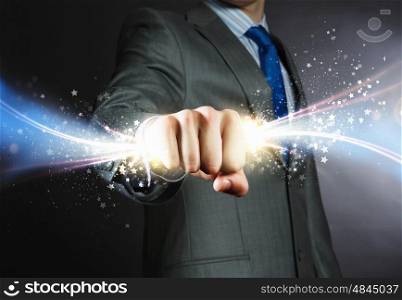 Star dust. Close up of businessman hand holding light ray in fist