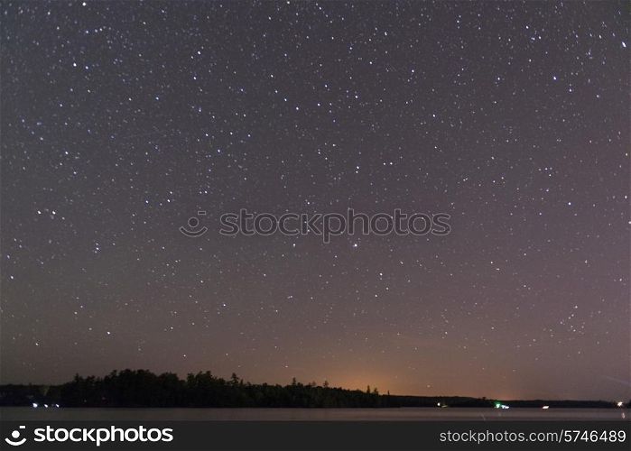 Star in the night sky over a lake, Lake of The Woods, Ontario, Canada