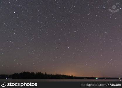 Star in the night sky over a lake, Lake of The Woods, Ontario, Canada