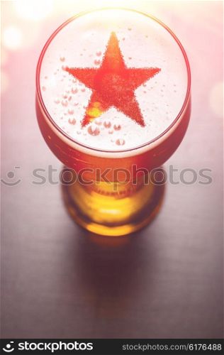 star symbol on foam in glass on black table, view from above