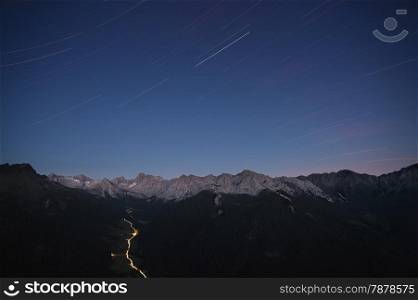Star tracks over mountain range. Dolomites mountains, Italy