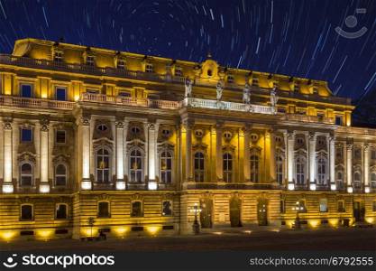 Star Trails in the early Spring sky over Buda Castle in the city of Budapest in Hungary. The star trails show the rotation of stars during a long exposure around Polaris, the Pole Star.