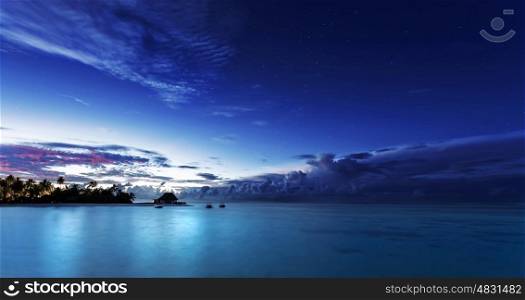 Starry night on Maldives, dark blue night sky over beach resort, beautiful nighttime seascape, luxury summer vacation and tourism concept