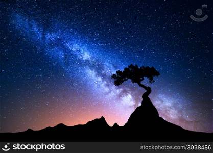 Starry sky with blue Milky Way. Night landscape. Starry sky with blue Milky Way. Night landscape with alone tree on the mountain peak against colorful milky way. Amazing galaxy. Nature background with beautiful universe. Astrophotography