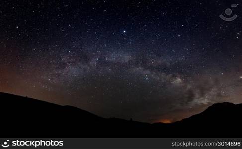 Starry sky with Milky way and silhouette of mountains
