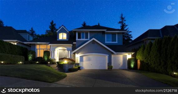 Stars coming out in late evening with front view of modern suburban home and yard