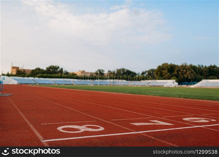 Start line for running on stadium, nobody, front view. Empty treadmill with numbers, injury-proof coating, jogging surface on sport arena. Start line for running, nobody, front view