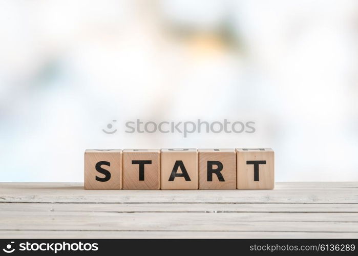 Start sign made with cubes on a wooden table