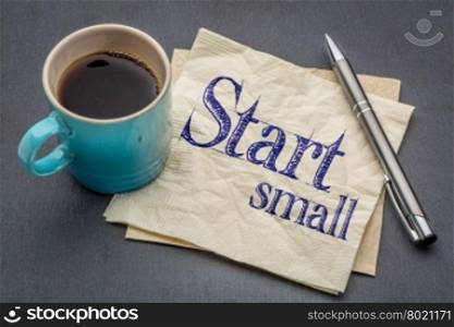 start small advice - handwriting on a napkin with cup of coffee against gray slate stone background