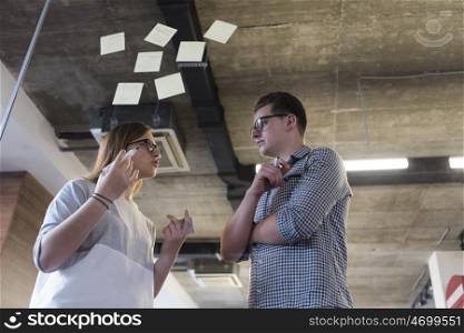 start up business planning and making organization with young couple at modern office interior writing notes on stickers