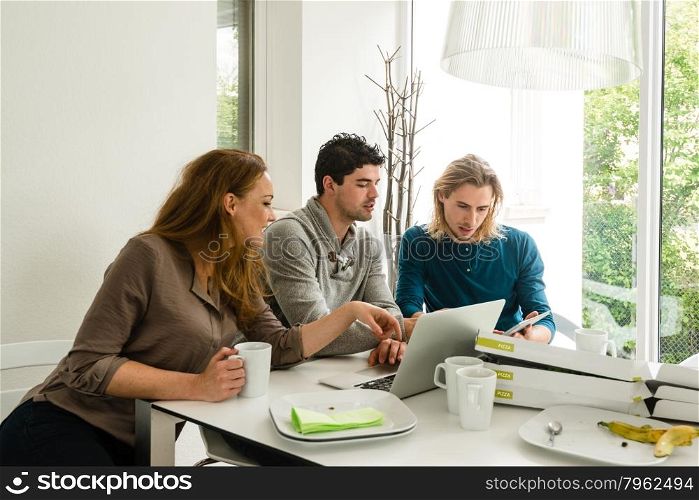 Start-up business team in meeting, working on computer after having pizza in a bright room