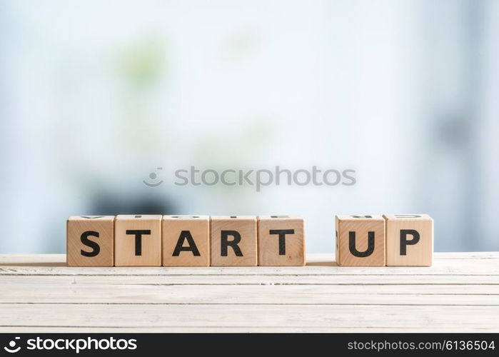 Start up sign on a wooden office desk