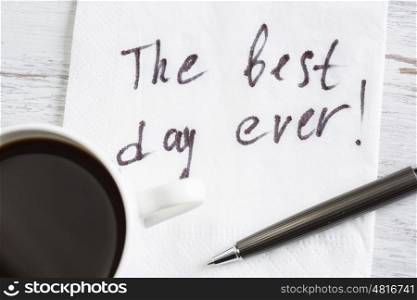 Start your day with positivity. Best day ever message written on napkin and cup of coffee