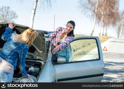 Starting broken car two women have problems looking under hood